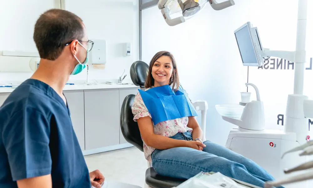 Aplicação profissional de gel branqueador numa consulta de branqueamento dentário em ambiente clínico.
